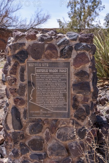 Plaque on stone historical marker provides information on the historic wagon road through Arizona