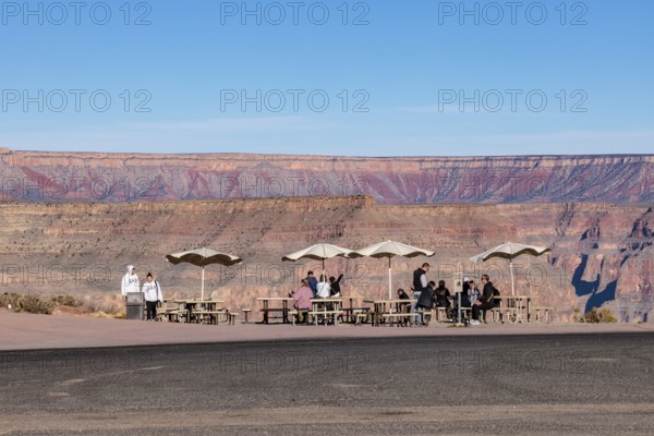 Tourists waiting for bus transportation at covered picnic tables at Guano Point in Grand Canyon