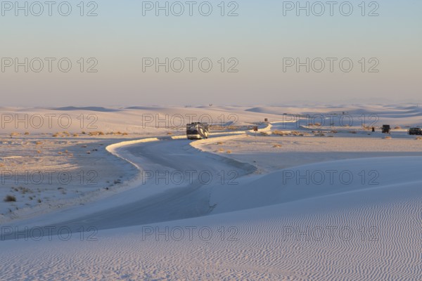 Motorhome being driven on cleared road through the white gypsum dunes at White Sands National Park