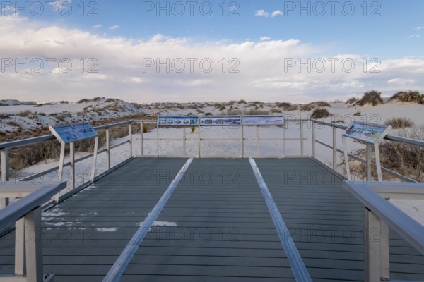 Signage informs visitors about dunes and wildlife along the Interdune Boardwalk over the gypsum
