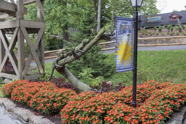 Sculpture of a boy chasing a dog chasing a cat up a tree at the Dollywood amusement park in Pigeon