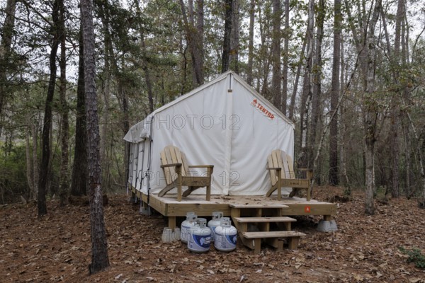 Propane tanks outside a Tentrr glamping tent on a raised platform with a wooden porch at Clarko