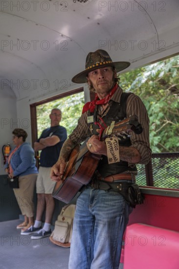 Singer and entertainer travels from car to car singing songs to the passengers for tips on the
