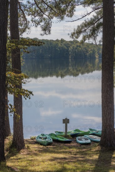 Plastic rental kayaks, canoes and paddleboards on the shore of Pin Oak Lake at The Lodge hotel in