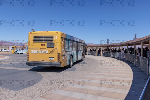 Visitors line up under shaded walkways waiting for busses to take them to the attractions at Grand