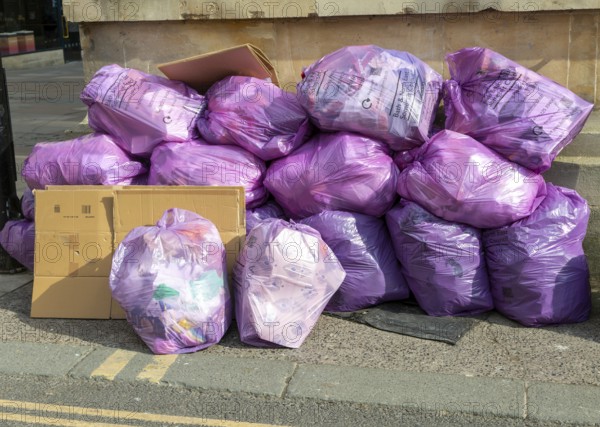 Council bags of rubbish waste piled on street corner, city of Bath, north east Somerset, England,
