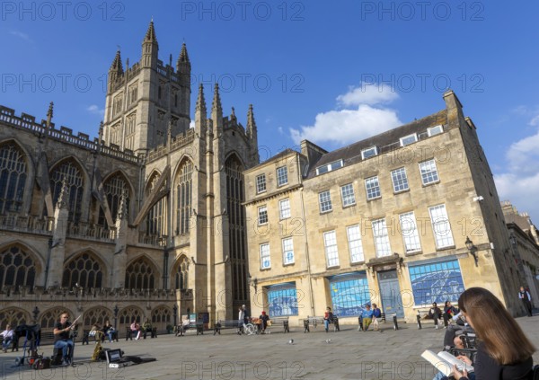 Busker musician performing in Bath Abbey church yard, city of Bath, north east Somerset, England,