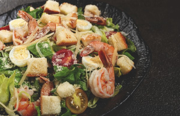 Caesar salad with tiger prawns, shrimp salad, lettuce leaves, quail eggs, cherry tomatoes, parmesan