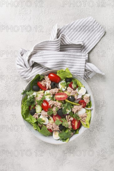 Salad with canned tuna, vegetable salad with quail eggs, lettuce and romaine leaves, red onion,