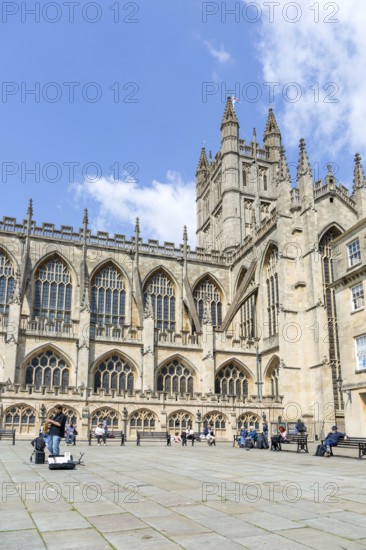Busker musician performing in Bath Abbey church yard, city of Bath, north east Somerset, England,