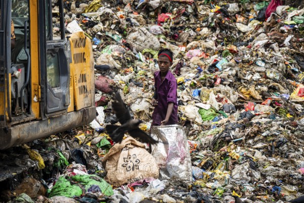 Garbage collectors searching for recyclable material at garbage disposal site, in Assam, India on