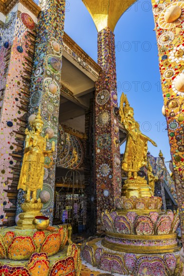 Gilded Buddha statues standing on pedestals decorated with mosaics and glass works of art, Buddhist
