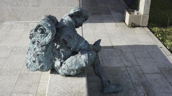 Stone figure of a seated pilgrim with backpack in the sun, pilgrims on the Caminho Portugues,