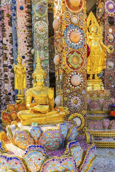 Gilded standing Buddha statues standing on pedestals decorated with mosaics and glass works of art,