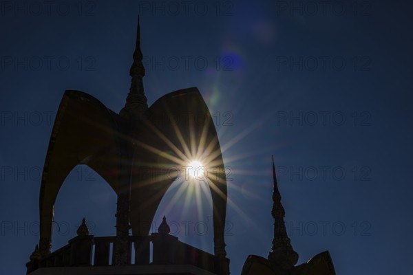 The sun shines through a round arch pavilion, Wat Phra That Sorn Kaew Buddhist temple complex,