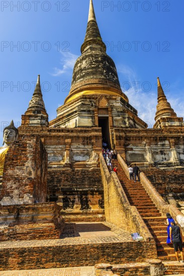 Visitors on steep stairs to the entrance of a temple tower, Prang, historic Buddhist temple