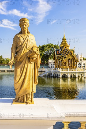 Stone female figure on Dolls Bridge, in the back the open, gilded pavilion, Buddhist temple