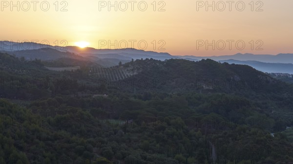 Wide landscape with hills at dusk, sunset behind the mountains, Hotel Europa, garden restaurant and