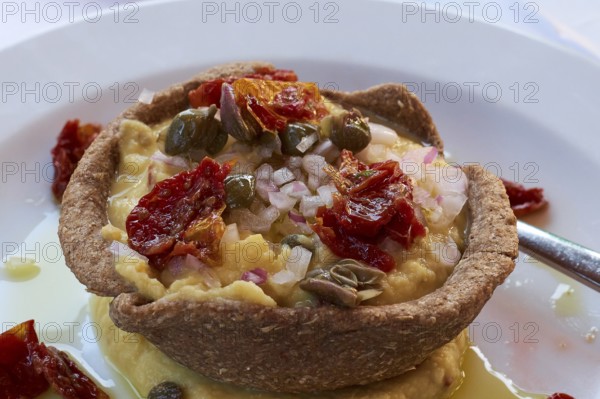 Mediterranean starter with fresh ingredients such as dried tomatoes and capers on a plate, Hotel
