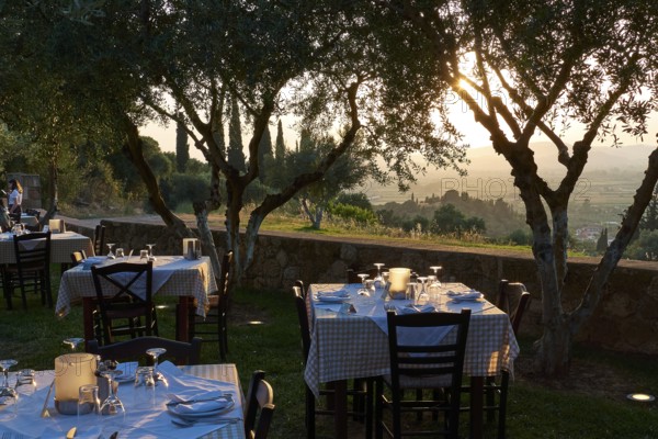 Several outdoor tables set under trees with evening lighting, Hotel Europa, garden restaurant and