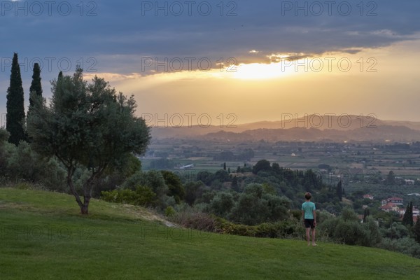 Person standing in the foreground, looking at a vast landscape in the evening light, Hotel Europa,