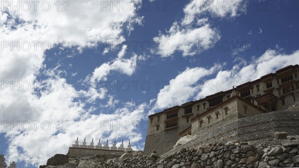 Stone Buddhist monastery building under a dramatic sky full of clouds, trekking in Ladakh,