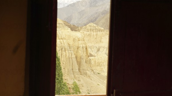 View from a dark window of a rocky, desert-like mountain landscape, trekking in Ladakh, Himalayas,