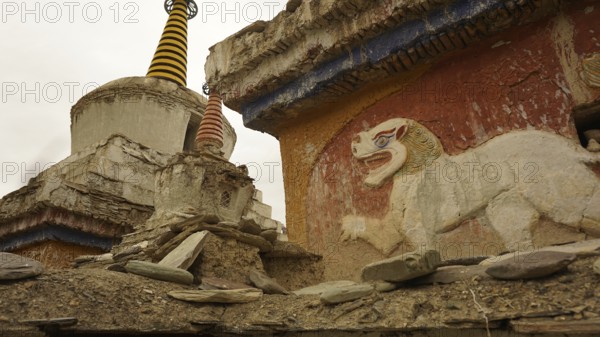 Historic temple wall with lion relief and stupa decoration in an old complex, trekking in Ladakh,