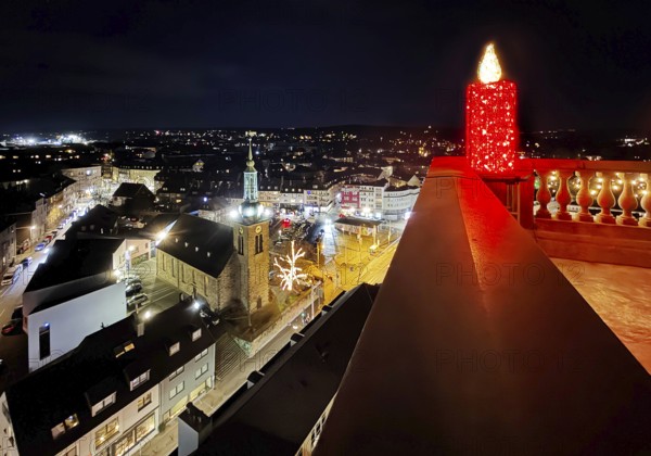 Large candle sculpture for Advent on the town hall tower in the evening with a view of St. John's