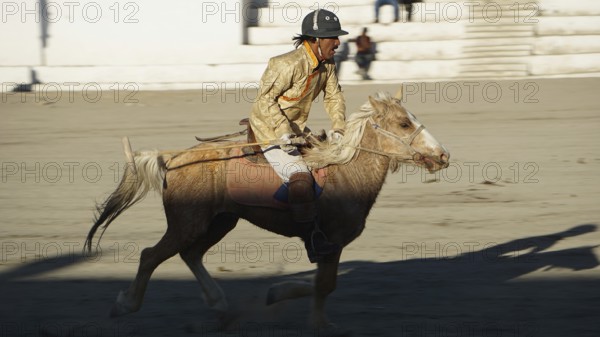 Single rider on horseback playing polo in traditional clothing on a horse moving, trekking in