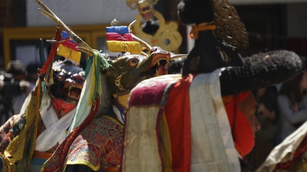 People wearing traditional masks and colorful costumes in a cultural ceremony in Leh, trekking in