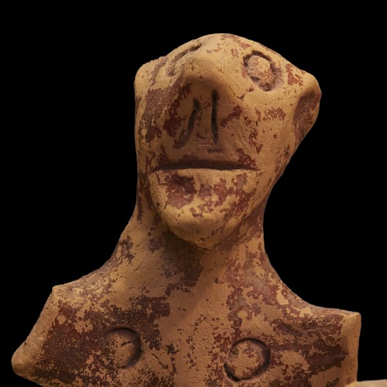 Anthropomorphic votive statuette, clay figure with abstract facial features and antique-looking