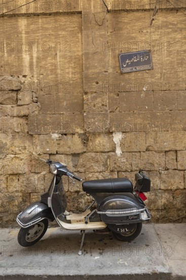 Cairo, Egypt. July 7th 2024 A grey coloured scooter parked in the narrow alley ways of the