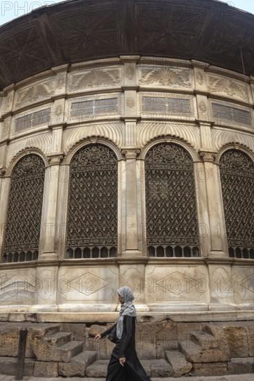 Cairo, Egypt. July 7th 2024 A local woman walks past one of the many restored monuments along