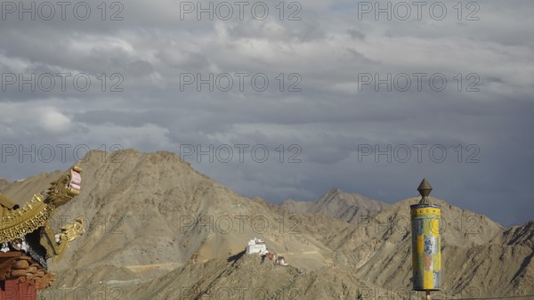 View towards Namgyal Tsemo monastery, dramatic sky with pediment of a Buddhist temple with Tibetan