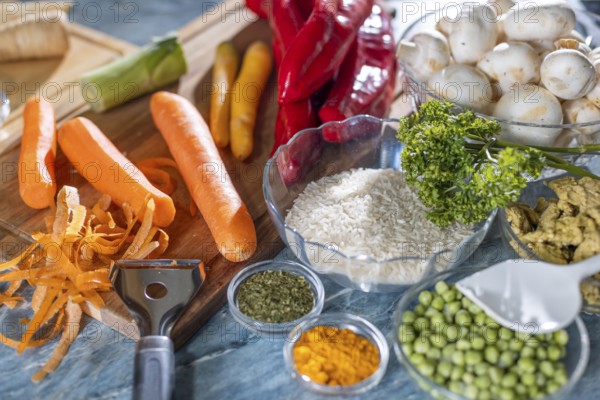 Fresh ingredients and spices such as peppers, peas, rice, mushrooms and peeled carrots