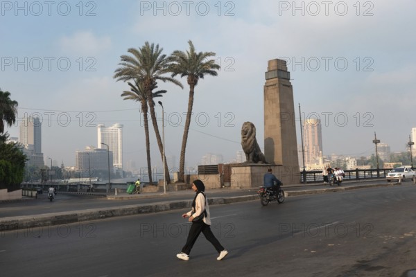 Cairo, Egypt. July 1st 2024 A young muslim Egyptian woman crosses Qasr El Nile Bridge in the early