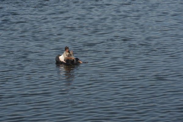 Qanater, Nile Delta. Egypt. December 18th 2022 An Egyptian man fishing from a makeshift inflatable