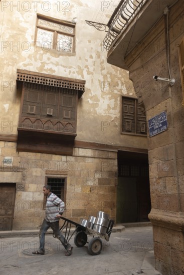 Cairo, Egypt. December 7th 2022 People walk by traditional Arabic Islamic architecture Mashrabiya
