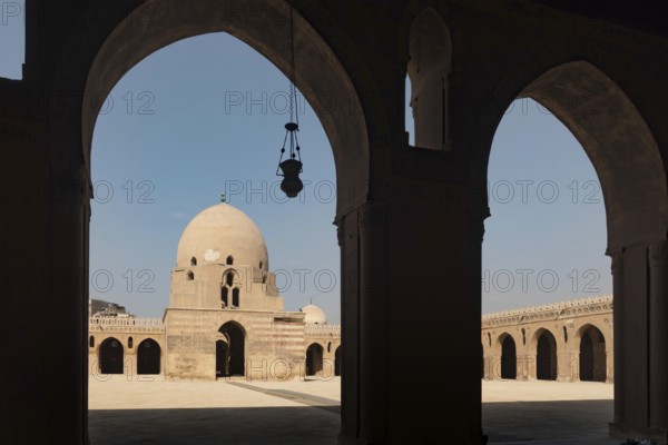Silhouetted arches of the interior architecture and courtyard showing the dome of Ibn Tulin Mosque