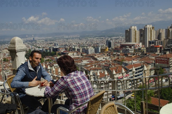 Bursa, Turkey. April 21st 2014 A couple drink tea with the Skyline of the Turkish city of Bursa,