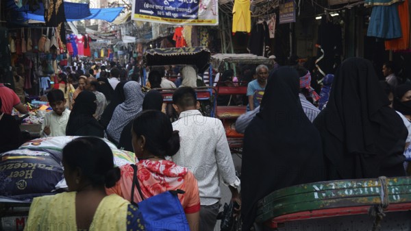 Dense crowd in a market scene with lots of rickshaws and hustle and bustle in a Muslim quarter of