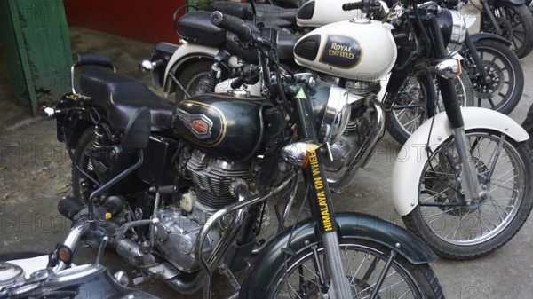 Row of parked Royal Enfield motorcycles in an outdoor area, Manali, Himachal Pradesh, India