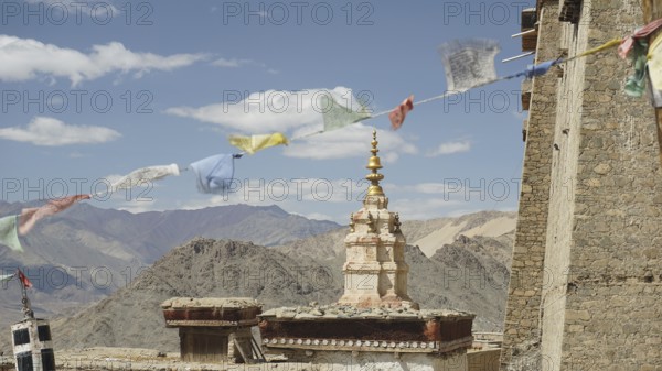 Traditional tower with prayer flags and mountain scenery in the background near Leh, Ladakh, North