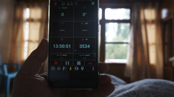 View of a smartphone showing altitude, interior view of a bedroom, Leh, Ladakh, North India,