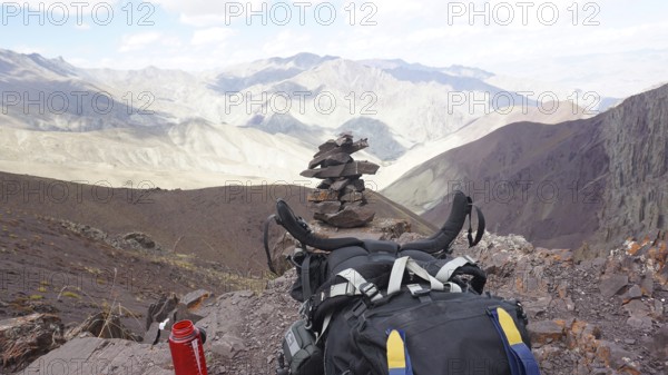 Break at the highest point of Stok La Pass, backpack in the foreground with rocky mountain scenery,