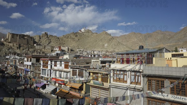View of Leh pedestrian street with traditional buildings, Leh Palace and mountain scenery in the