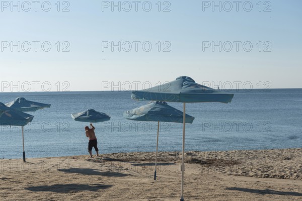 Varna, Bulgaria. September 5th 2020 Setting out sunshade umbrellas on the beach in Varna on the