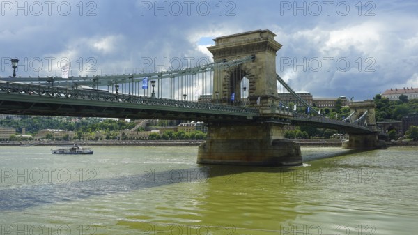 The Szechenyi Chain Bridge across the Danube under a cloudy sky, connection between Buda and Pest,