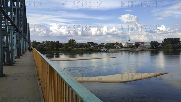 River landscape with two sandbanks in the Vistula with metal bridge, clouds and view of Torun city,